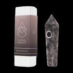 Black tourmaline gemstone pipe and its white packaging with a geometric logo.
