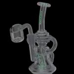 A translucent glass dab rig with green accents and a quartz banger, isolated on a black background.