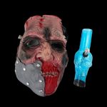 Horror-themed cannabis accessory display featuring a realistic zombie mask and a blue glass pipe against a black background.