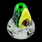 A close-up, angled view of the Empire Glassworks Avocadope Carb Cap for Puffco Peak, showcasing its sculpted green glass design.