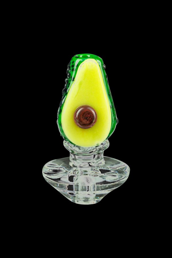 A close-up, angled view of the Empire Glassworks Avocadope Carb Cap for Puffco Peak, displaying its detailed, green avocado-shaped design.