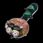 A detailed side view of the Empire Glassworks "The Owl" Mini Glass Spoon Pipe, featuring sculpted owl facial details in vibrant colors.