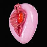 A close-up, angled view of the Empire Glassworks “Pink Panther” Hand Pipe, showcasing its smooth, curved form in shades of pink.