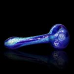 Blue glass smoking pipe with glitter effect, reflecting on a black surface.