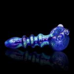 Blue glass pipe with swirling iridescent patterns, reflecting on a dark surface.