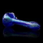 Blue glass pipe with glitter flecks, reflecting on a dark surface.