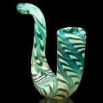 Green glass cannabis water pipe with swirling patterns, reflected on a black surface.