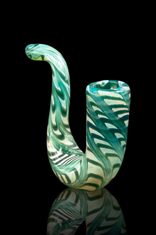 Green glass cannabis water pipe with swirling patterns, reflected on a black surface.