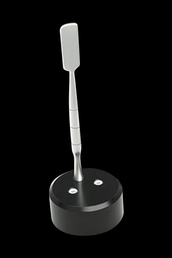 Silver dab tool resting in a black base with two small indentations.