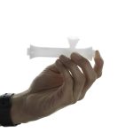 A hand holds the Jane West Cloud White Steamroller, showcasing its sleek, white design against a plain backdrop.