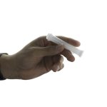 A hand holds the Jane West Cloud White Taster, showcasing its simple, streamlined shape against a neutral background.