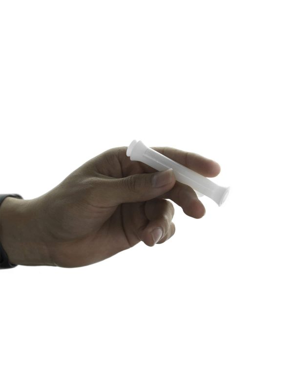 A hand holds the Jane West Cloud White Taster, showcasing its simple, streamlined shape against a neutral background.