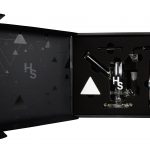 A studio shot displays the Higher Standards Heavy Duty Rig against a dark background with subtle triangular patterns.