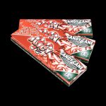 A close-up shot of a pack of Juicy Jay's Classic Size Flavored Rolling Papers, angled slightly to reveal the colorful branding and text.