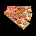 A stack of Juicy Jay's Classic Size Flavored Rolling Papers is shown from a slight angle against a dark background.