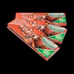 A close-up of a package of Juicy Jay's Classic Size Flavored Rolling Papers against a black background.