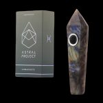 Labradorite gemstone pipe and its branded packaging, presented against a black background.