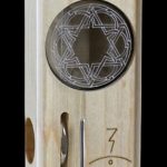 Wooden cannabis storage box with a geometric patterned window and silver latch.