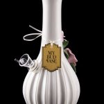 Elegant white glass water pipe with floral accents and a label reading "My Bud Vase," displayed against a black background.