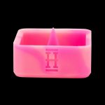 Pink silicone cannabis concentrate container with a geometric logo.