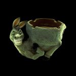 Ceramic donkey ashtray with a textured green finish, isolated on a black background.