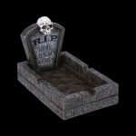 A Halloween-themed ashtray shaped like a graveyard plot, with a skull and "RIP HERE LIES MY ASHES" inscribed on a tombstone.