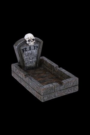 A Halloween-themed ashtray shaped like a graveyard plot, with a skull and "RIP HERE LIES MY ASHES" inscribed on a tombstone.