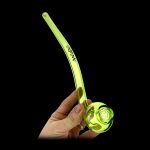 A hand holding a vibrant green glass oil rig with a bubbler attachment against a black background.