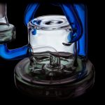 A vibrant glass rig with blue and green accents, designed for cannabis concentrate use.