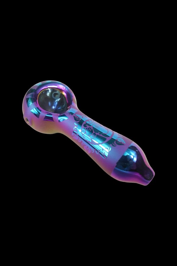 Iridescent glass pipe with etched floral designs, isolated on a black background.