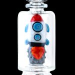 Glass rocket ship-shaped cannabis water pipe inside a clear display jar.