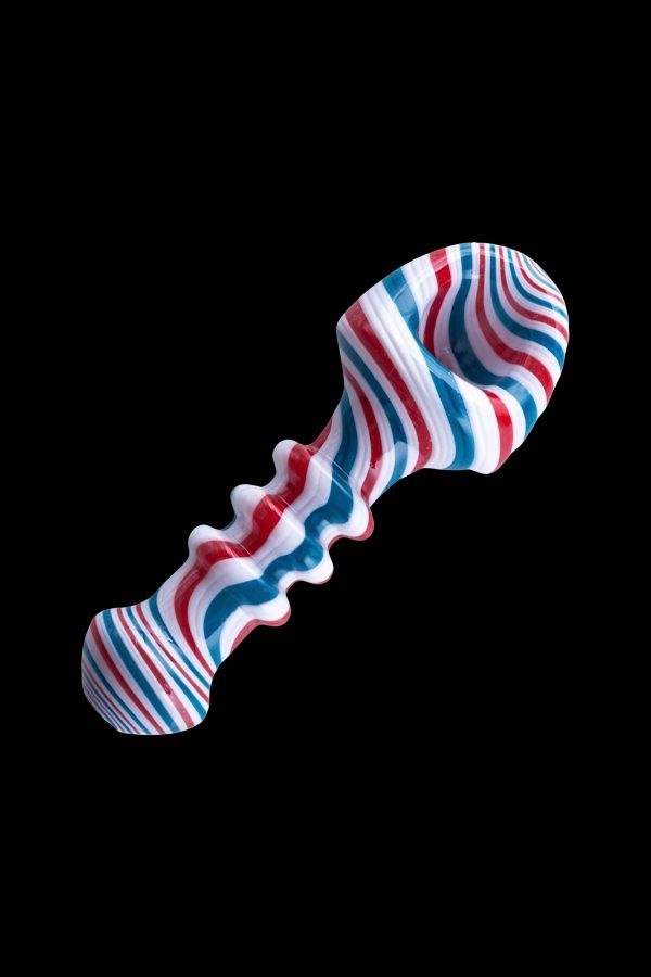 Red, white, and blue glass pipe isolated on a black background.