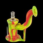 Colorful silicone dab rig with a glass bowl and carb cap, isolated on a black background.