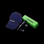 A navy blue baseball cap and green cannabis rolling tray and lanyard, all branded with "HUMAN SUCKS" against a black background.