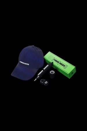 A navy blue baseball cap and green cannabis rolling tray and lanyard, all branded with "HUMAN SUCKS" against a black background.