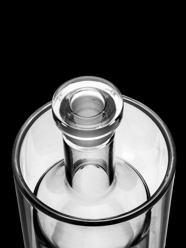 Clear glass bubbler with a removable downstem, isolated on a black background.