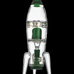 Glass rocket ship-shaped water pipe with green accents, isolated on a black background.