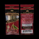 Close-up of two King Palm pre-rolled cones—"Cherry Charm" and "Vision"—in red packaging, highlighting the brand logo and flavor names, with text indicating “Terpene Infused - Tobacco Free” and a half-gram size.