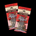 Two packs of “King Palm” red apple flavored rolling cones against a black background.