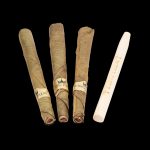 Four pre-rolled cannabis blunts and a wooden rolling tray on a black background.