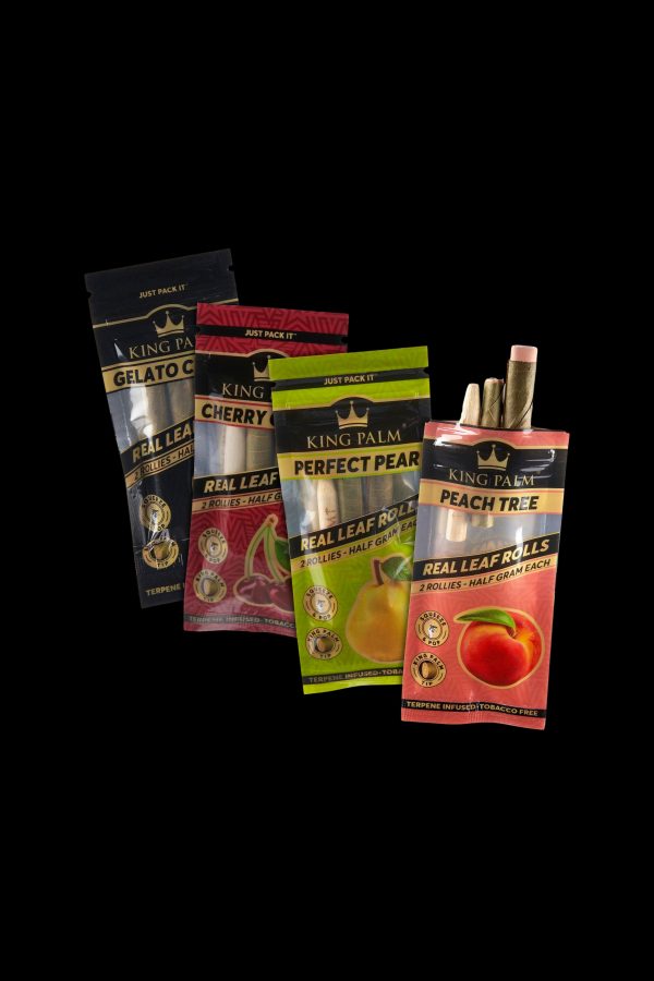 Assortment of colorful King Palm pre-rolled cones and packaging, including flavors like gelato, cherry, and peach, against a dark background.