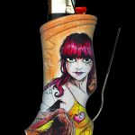 A lighter sleeve with a detailed illustration of a stylized, gothic-inspired woman holding a heart, accompanied by a metal tool, against a black background.