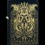Gold-toned Cthulhu-inspired lighter with intricate, occult-style border and “R’LYEH” inscription on a black background.