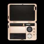 Gold cannabis storage case open, displaying compartments for a vape pen, cartridges, and tools.