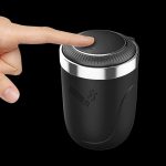 Close-up of a hand pressing the button on a black cannabis grinder.