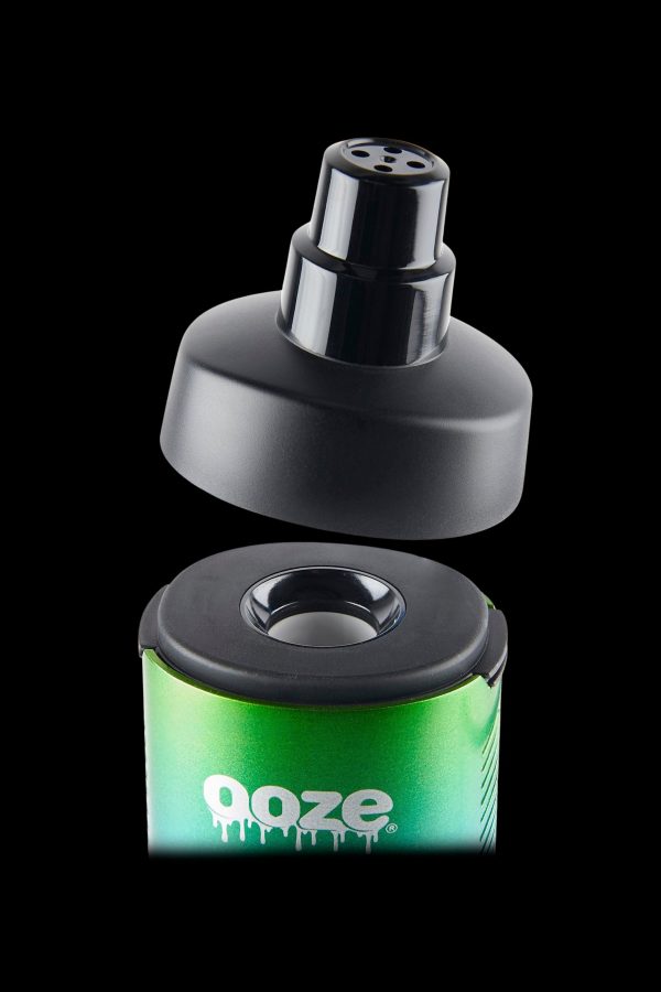 Green and black cannabis concentrate container with removable lid.