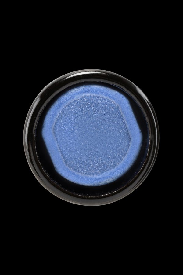 Blue cannabis concentrate in a small glass jar.