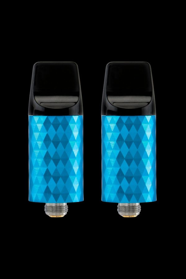 Two blue cannabis oil vape cartridges with geometric patterned bodies against a black background.