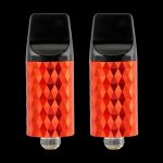 Two red, diamond-patterned cannabis vape cartridges against a black background.