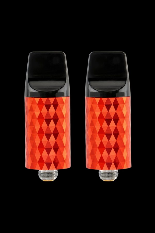 Two red, diamond-patterned cannabis vape cartridges against a black background.
